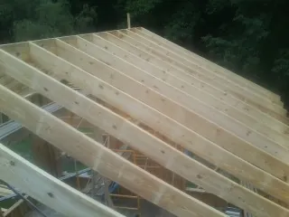 New roof rafters set over an addition before sheathing in Middleport